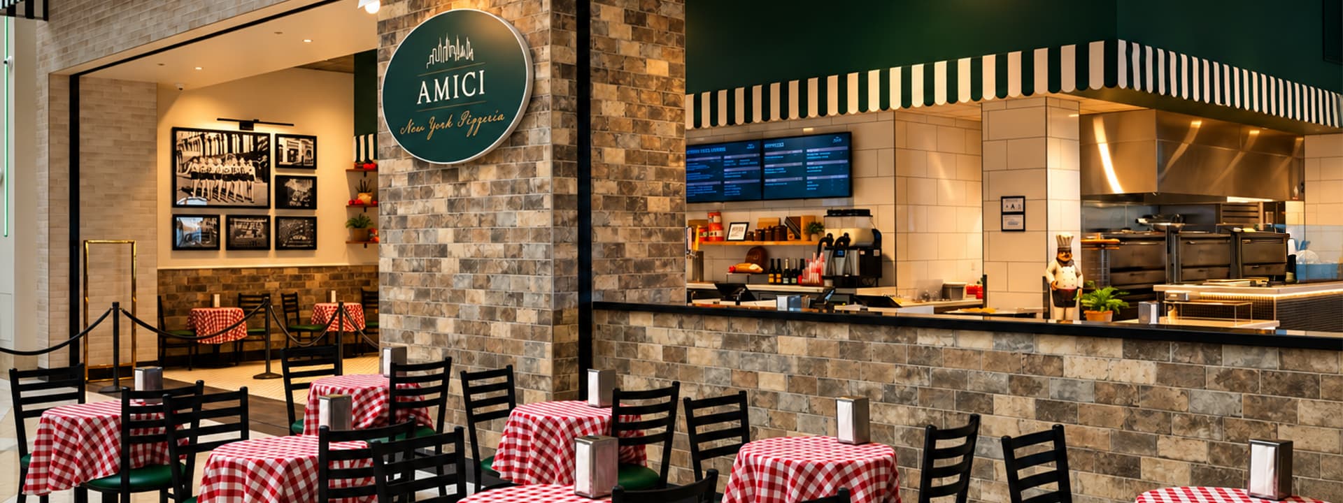 Amici New York Pizzeria dining area with red-and-white checkered tables, open kitchen, and restaurant signage.