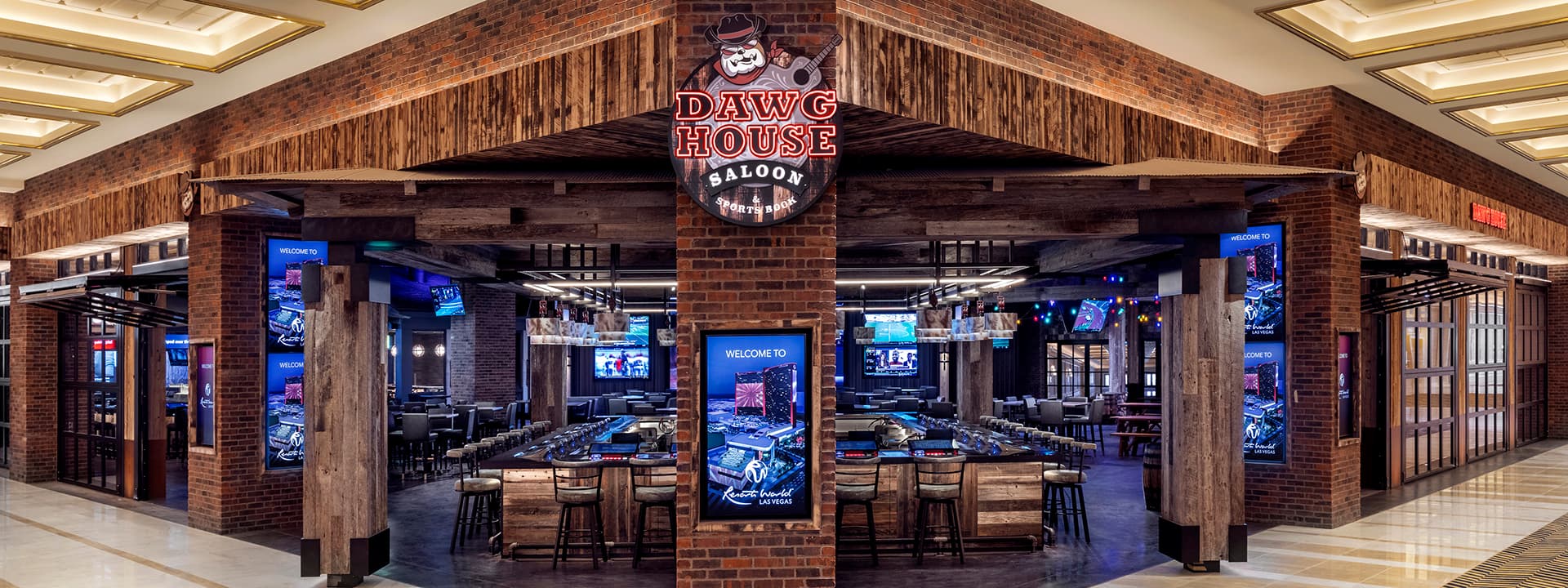 Entrance to Dawg House Saloon at Resorts World Las Vegas, featuring a rustic brick and wood exterior with an open bar and multiple sports screens inside.