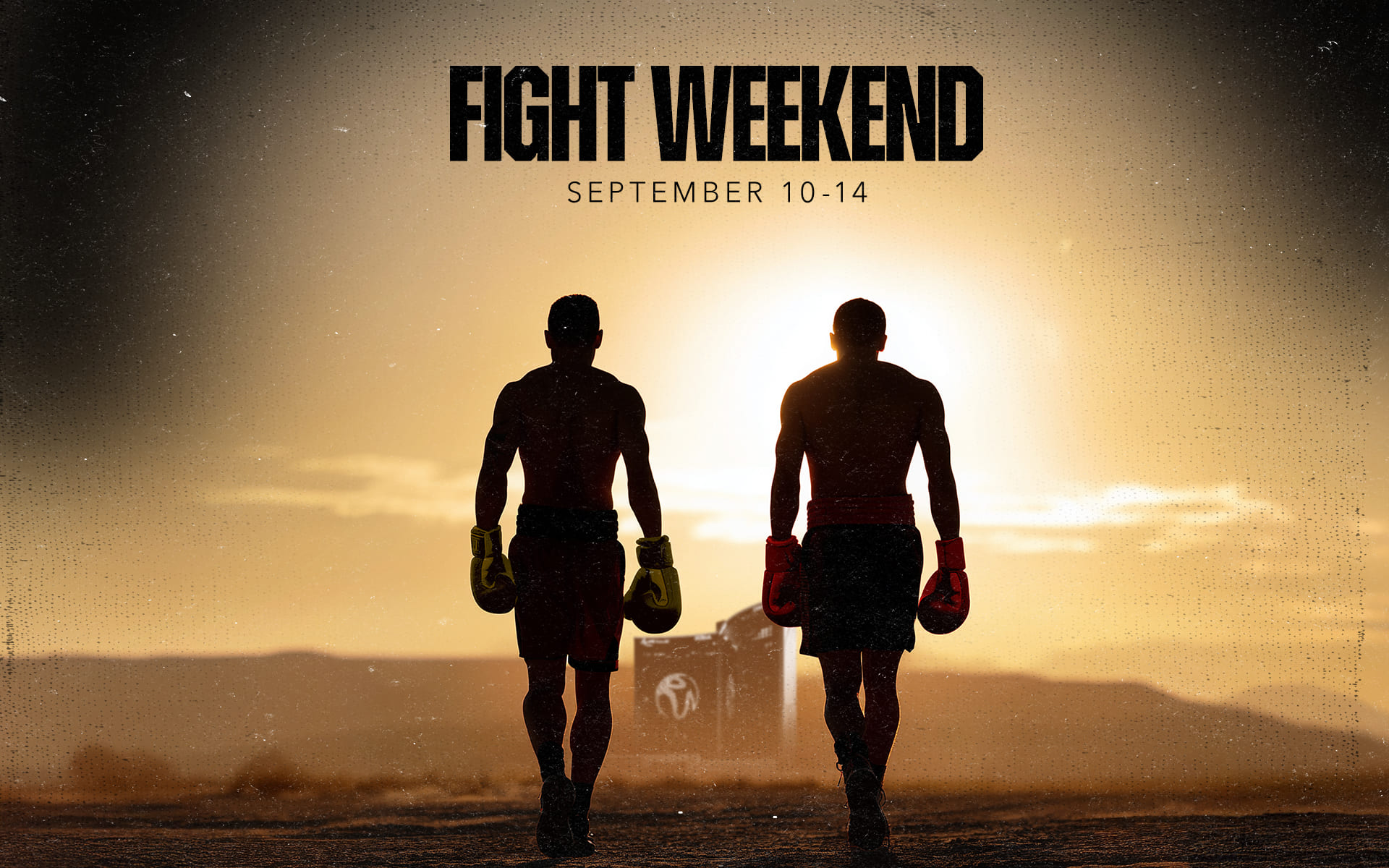 Two boxers with gloves walking toward each other at sunset during Fight Weekend, September 10–14.