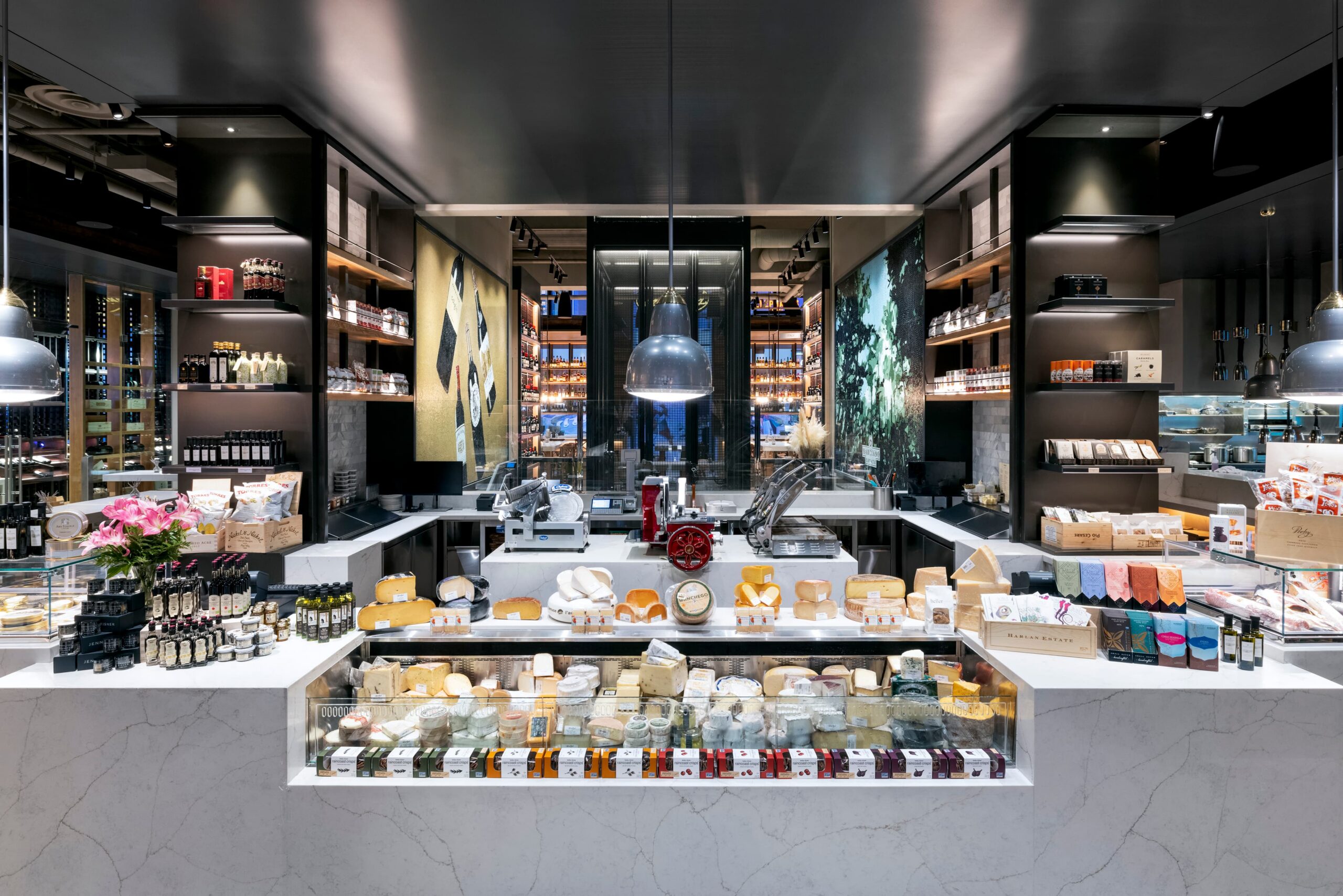 Modern gourmet market interior with cheese display, specialty foods, and deli counter