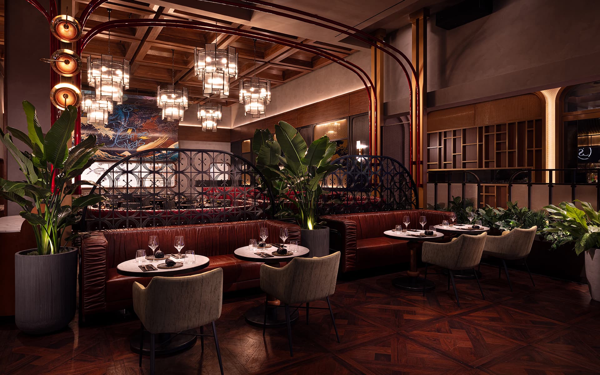 Upscale dining area at Stubborn Seed featuring leather banquette seating, marble tables, warm pendant lighting, tropical plants, and elegant contemporary décor.