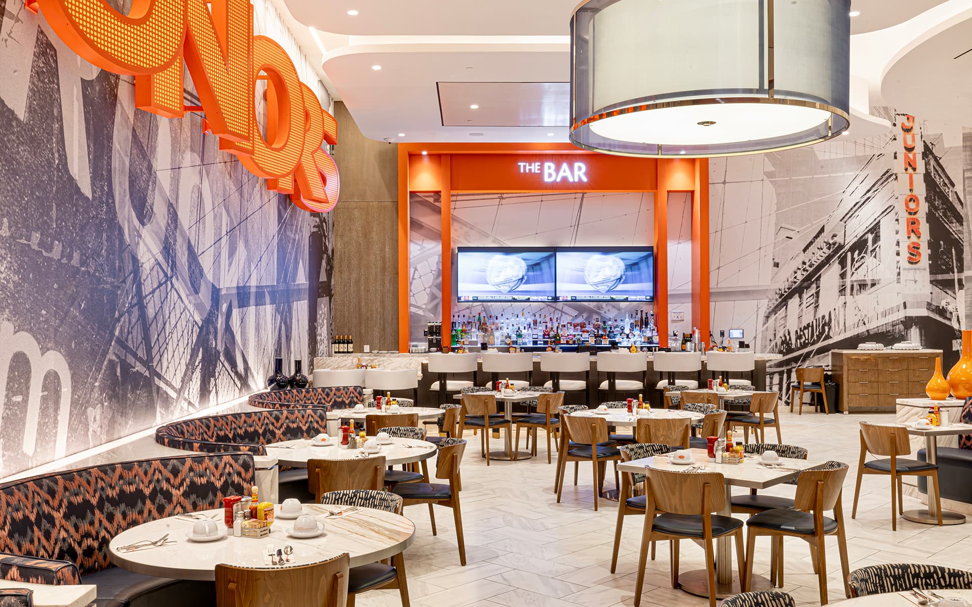 Interior of Junior’s featuring dining tables, booth seating, and a bar area.
